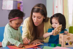 Teacher helping toddlers build reading skills